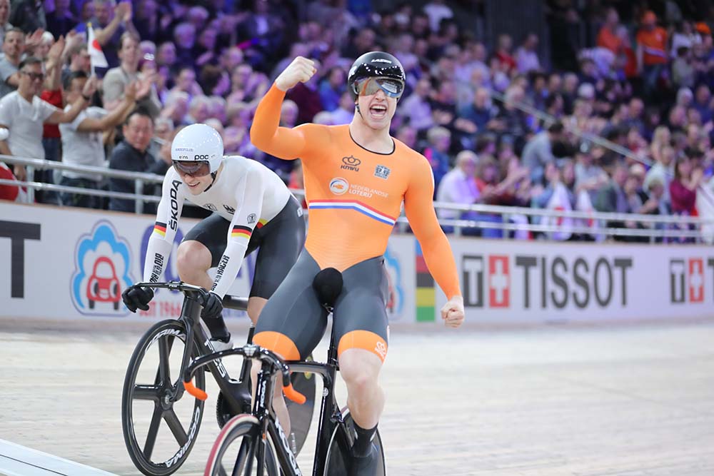 Fietser in oranje outfit viert overwinning op het podium