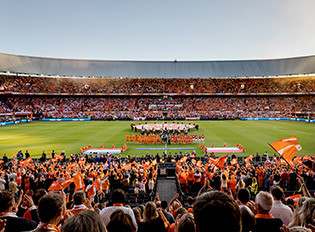 Vol stadion met fans in oranje tijdens een sportevenement