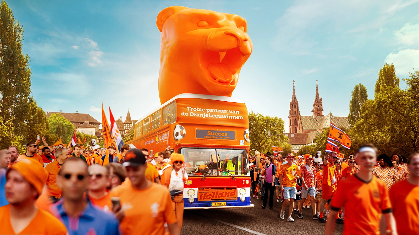 Oranje parade met een bus en een grote oranje beer erop