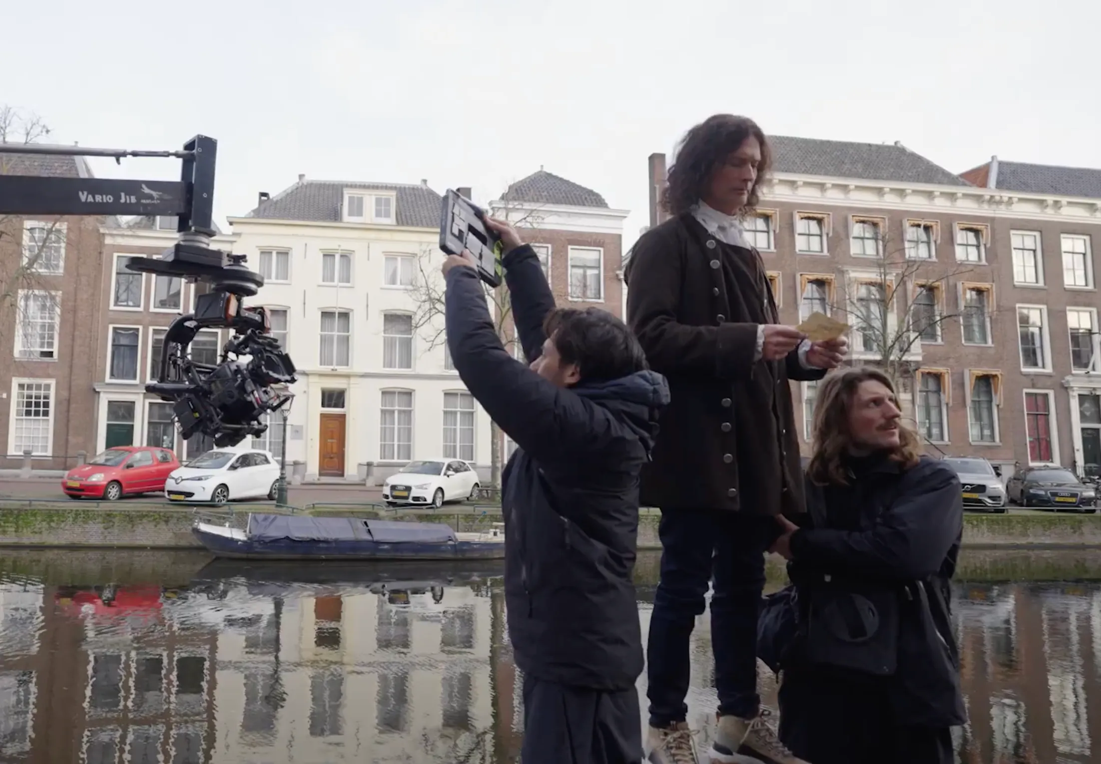 Filmpresentatie met camerateam en acteur aan het water.