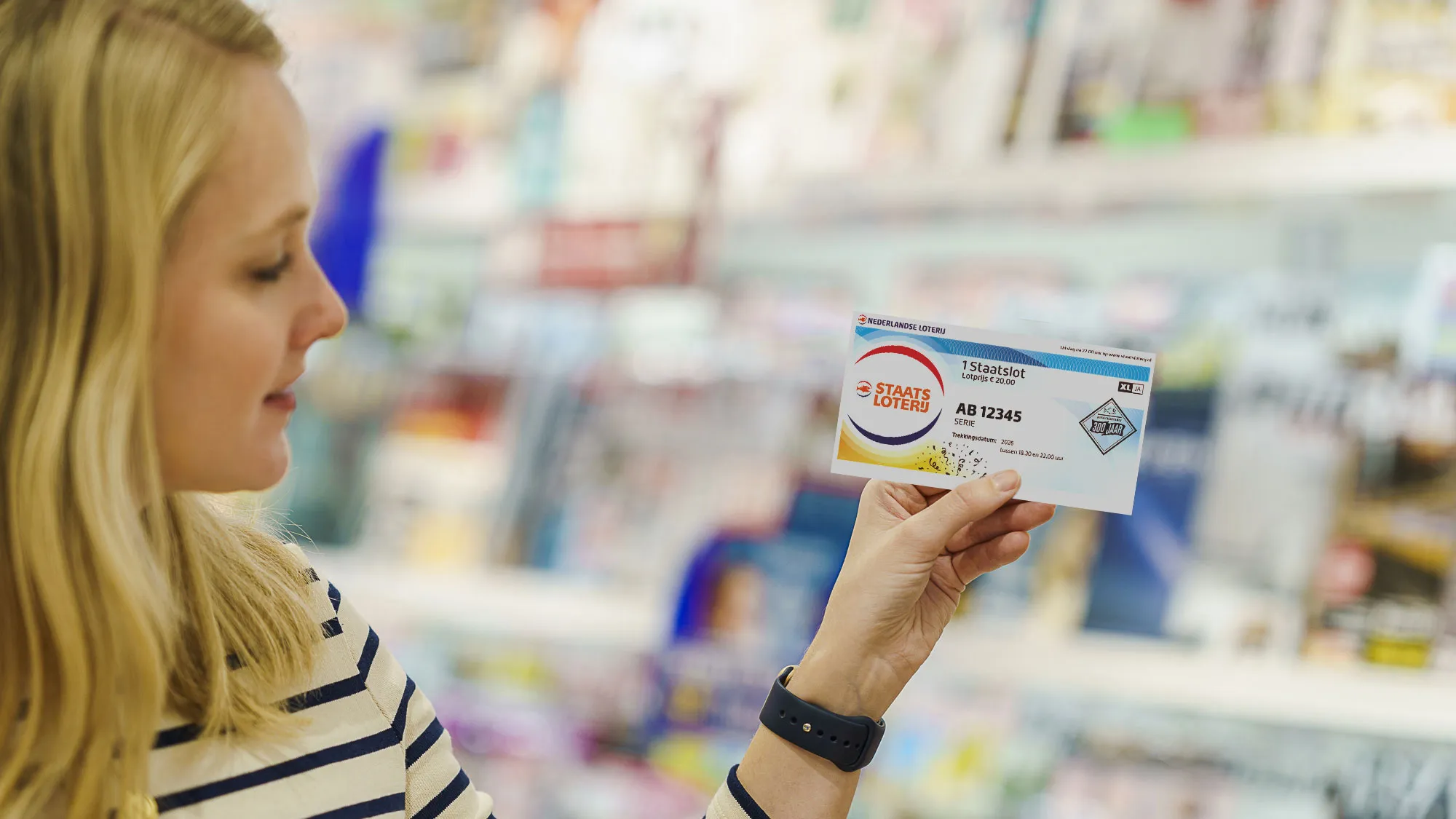 Persoon met een 1 Staatslot in de hand, met tijdschriften op de achtergrond.