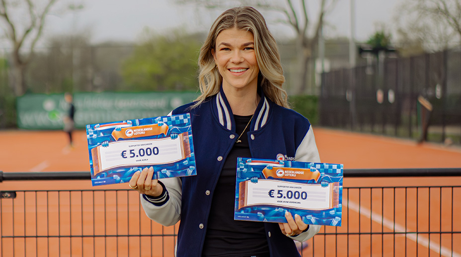Tess Lieder toont twee cheques van € 5.000 op een tennisbaan.
